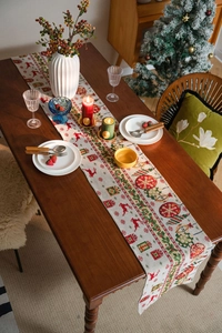 Cozy Christmas table runner with reindeer and snowflake patterns on a festive wooden table