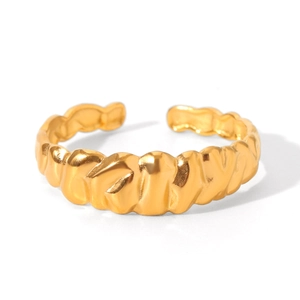 Detailed close-up of golden adjustable ring featuring a textured wave croissant pattern