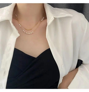 Detailed close-up of double-layer titanium steel necklace with elegant white pearls