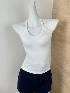 Detail of white ribbed V-neck tank top showing textured stretch fabric on a mannequin