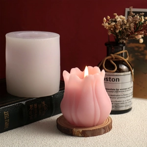Dettaglio dello stampo in silicone a tulipano e candela accesa su un libro vintage