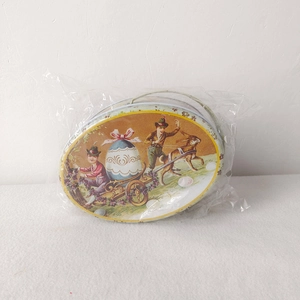 Detail showing vintage Easter tin box with rabbit and egg print and metal handle