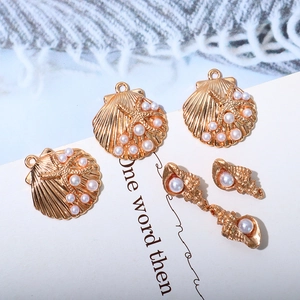 Macro shot of KC gold shell starfish charms and pearl stud earrings for DIY jewelry making