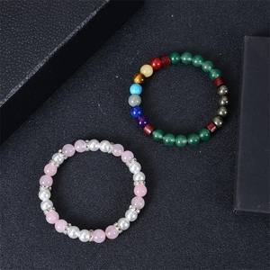 Close-up of colorful natural stone beaded bracelets on black textured surface