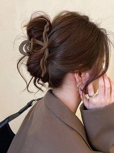 Detail of matte brown large shark hair clip on back of head for thick hair styling