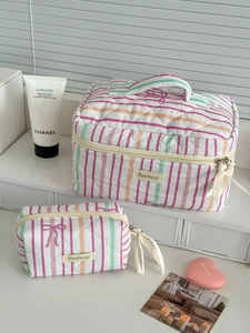 Detailed view of quilted striped makeup bag set with cute bow zipper and top handle