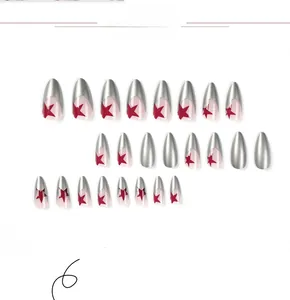 Detail of silver metallic press-on nails featuring red star designs in long pointed shape