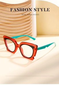 Detail of geometric cat-eye glasses with transparent red frames and turquoise temples
