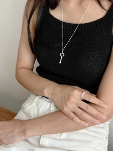 Minimalist silver key necklace and ring set styled on a model with black knitwear