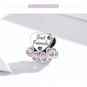 Macro shot of S925 sterling silver heart charm with pink zircon paw print and engraving