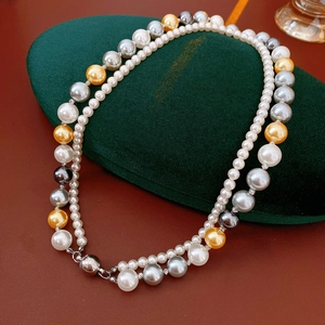 Détail d'un collier de perles double épaisseur avec perles blanches grises et fermoir magnétique