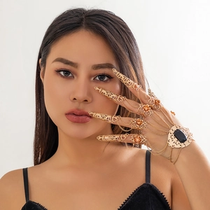 Bracciale ad anello gotico dorato con pietre nere e anelli floreali su una modella