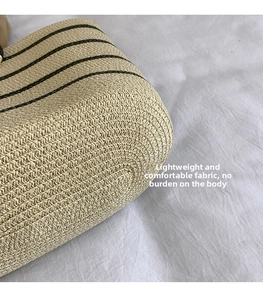 Detailed macro shot of beige woven straw tote with black stripes and fine texture