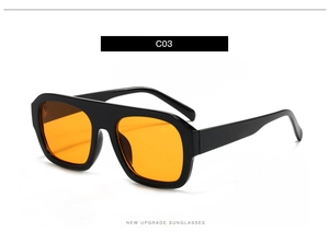 Detail of square oversized sunglasses with black glossy frames and orange tinted lenses