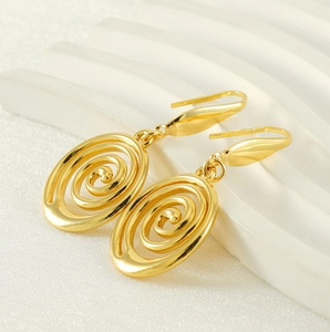 Detailed shot of gold plated stainless steel spiral swirl geometric earrings on white stand