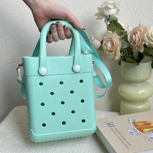 Detail of mint green EVA tote bag with perforations and adjustable shoulder strap