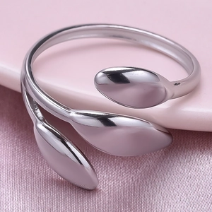 Makroaufnahme des silbernen Blätter-Rings mit Hochglanzoberfläche auf rosa Seide