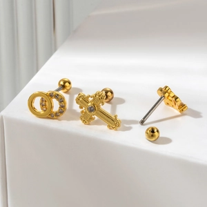 Close-up of three gold-plated stainless steel cartilage earrings with zircon on white block