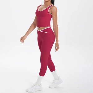 Detail view of high-waist yoga pants with cross-waist design and white piping trim