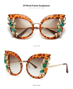 Detail of tortoiseshell cat eye sunglasses with green rhinestones and golden leaf accents