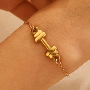 Minimalist gold titanium steel dumbbell bracelet shown on wrist for sports style