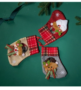 Three plush Christmas stockings with Santa, Snowman, and Reindeer on a green festive background
