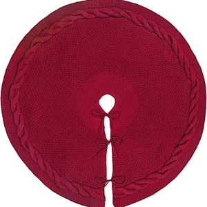 Red cable-knit Christmas tree skirt with decorative bow ties on a white background