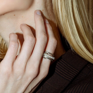 Close-up of multi-layer silver stainless steel ring with pearl accents on a model hand