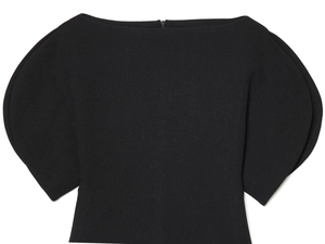 Detail of structured puff sleeves and crepe texture on a black off-shoulder top