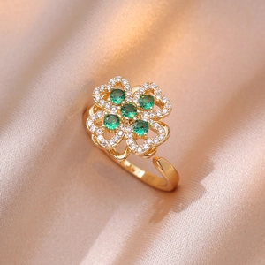 Vue macro de la bague trèfle dorée avec gemmes vert émeraude et cristaux micro-pavés
