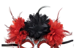Detailed close-up of carnival mask with red glitter, black lace flowers and feathers