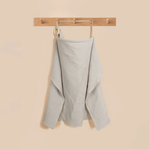 Detail of grey cotton waffle nursing cover featuring a wooden ring and adjustable strap