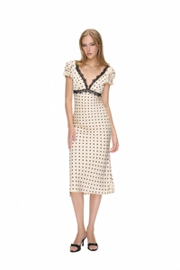 Detailed view of the V-neck with black lace trim on the beige polka dot midi dress