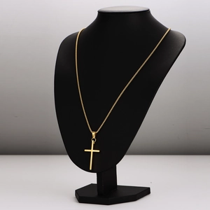 Minimalist gold cross pendant necklace on a black bust mannequin with a polished finish