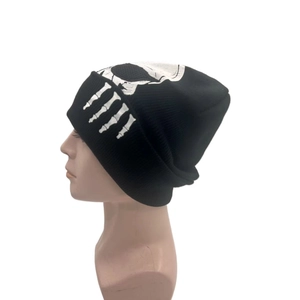 Winter knitted beanie featuring white skull and bone prints on black ribbed fabric