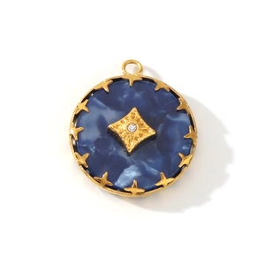 Detail of a round gold pendant with dark blue marble texture and a diamond star accent