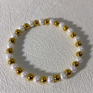 Detail of 18k stainless steel beaded bracelet with alternating gold and white pearls