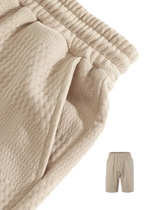 Vista macro dettagliata dei pantaloncini in maglia beige con coulisse e tasche