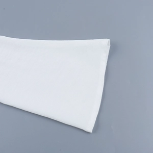 Close-up of white knitted dress featuring elegant bell sleeve detail and fine fabric texture