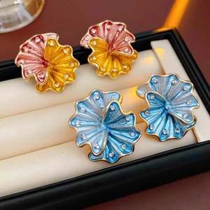 Vintage floral stud earrings with enamel petals and rhinestone accents in jewelry box
