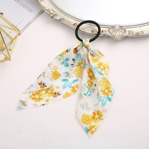 Detail of floral scrunchie with yellow and blue flowers and long ribbons on a white desk