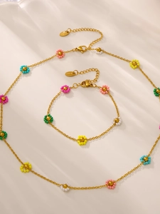 Detail of gold stainless steel necklace and bracelet set with colorful glass bead flowers