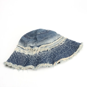 Detail of distressed denim bucket hat showing raw fringe edges and multi-tone wash