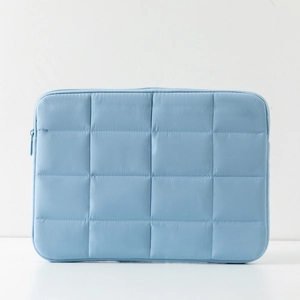 Close-up of light blue quilted laptop sleeve featuring waterproof fabric and zipper