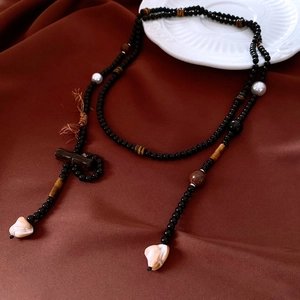 Detail of beaded necklace with tiger eye stone, bamboo wood and natural shell pendant