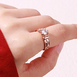 Close-up of rose gold wheat pattern ring with sparkling zircon stones on a model's hand