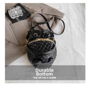 Detail showing owl shape bag with embossed feather texture and gold zipper eyes
