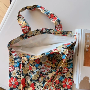 Detail shot of floral cotton tote bag featuring colorful prints and secure metal snap closure