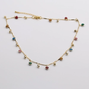 Détail du collier doré avec pendentifs en forme de cœur coloré et cristaux brillants
