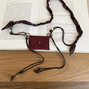 Retro burgundy mini bag with checkered scarf strap and wooden beads on vintage book